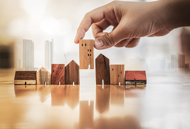 photo: hand with tiny wooden buildings (iStockphoto)