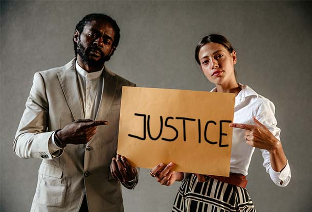 photo: man and women pointing at sign that says "justice" (iStockphoto)