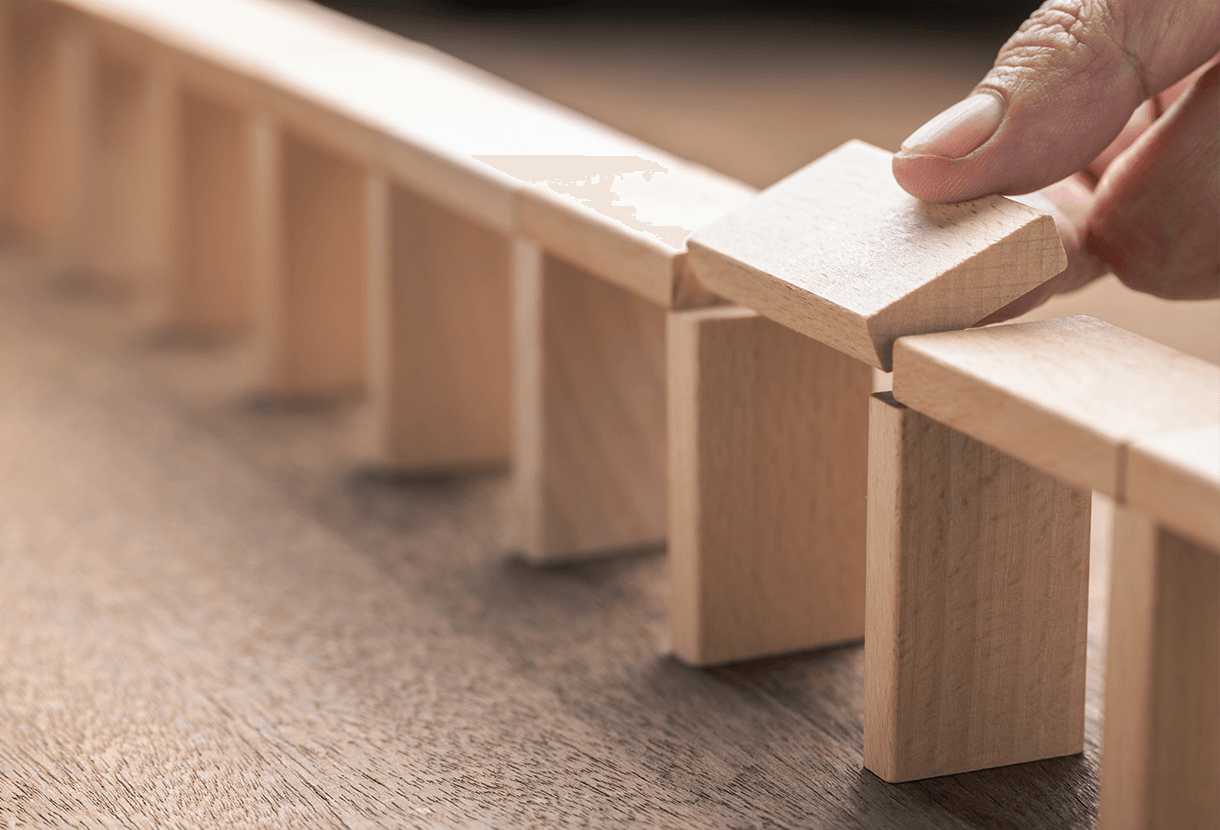 image: hand placing a wooden block forming a bridge (iStockphoto)