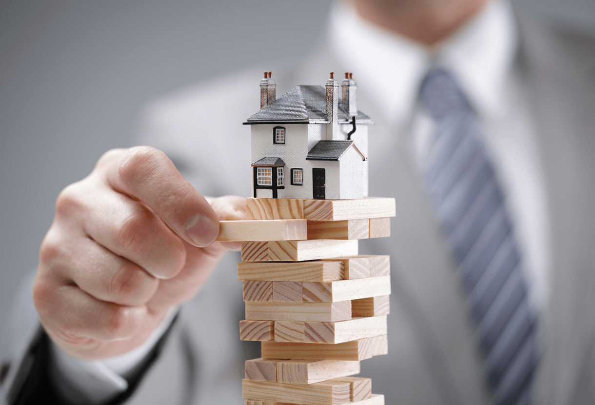 photo: hands removing blocks supporting a small house (iStockphoto)